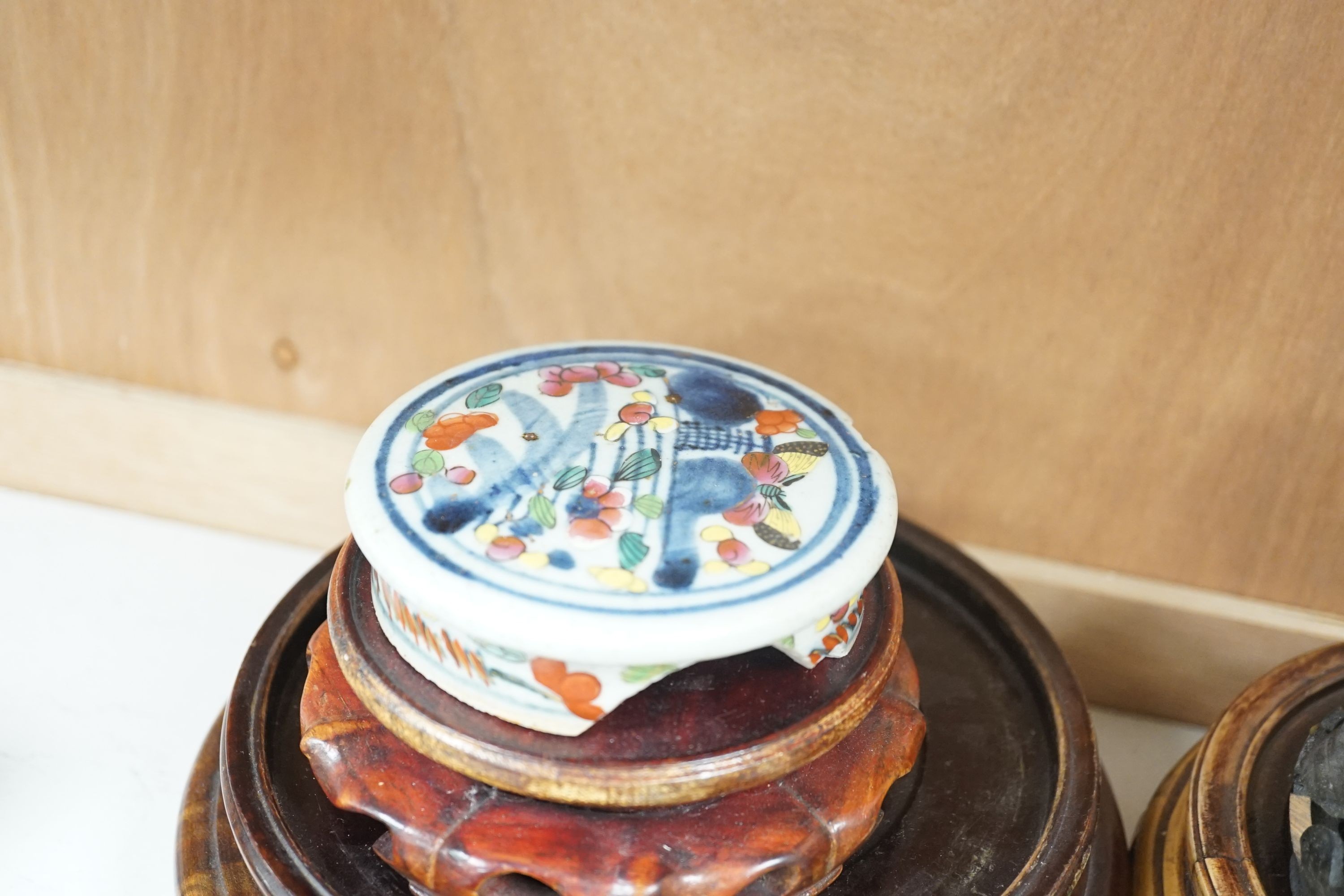 A group of Chinese wooden stands and three ceramics covers.